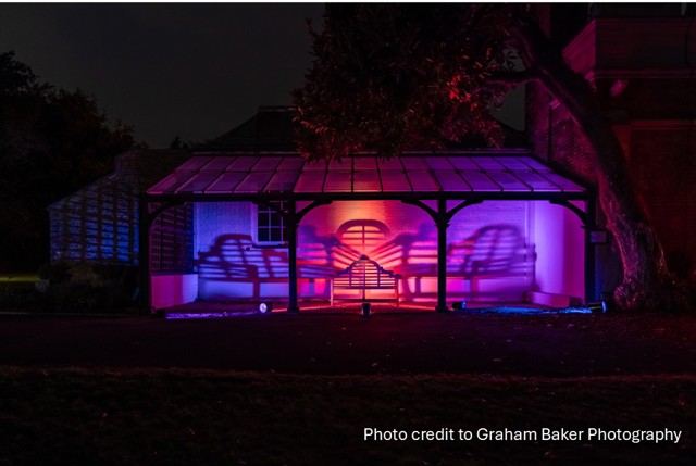 Benches bathed in coloured light under a gazebo